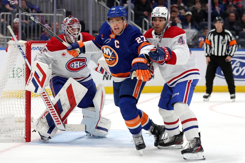 Mar 20, 2025; Elmont, New York, USA; New York Islanders left wing Anders Lee (27) fights for position against Montreal Canadiens defenseman Jayden Struble (47) and goaltender Sam Montembeault (35) during the second period at UBS Arena. Mandatory Credit: Brad Penner-Imagn Images