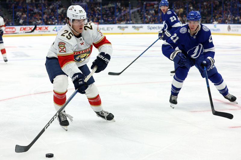 Oct 5, 2023; Tampa, Florida, USA;Florida Panthers right wing Mackie Samoskevich (25) skates with the puck as Tampa Bay Lightning center Brayden Point (21) defends during the first period at Amalie Arena. Mandatory Credit: Kim Klement Neitzel-USA TODAY Sports