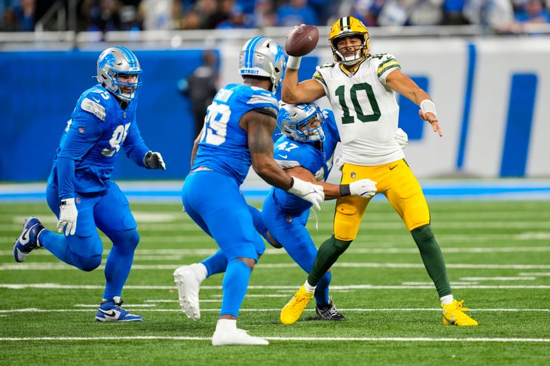 Green Bay Packers quarterback Jordan Love (10) is tackled by Detroit Lions linebacker Ezekiel Turner (47) during the first half of an NFL football game in Detroit, Thursday, Dec. 5, 2024. (AP Photo/Carlos Osorio)