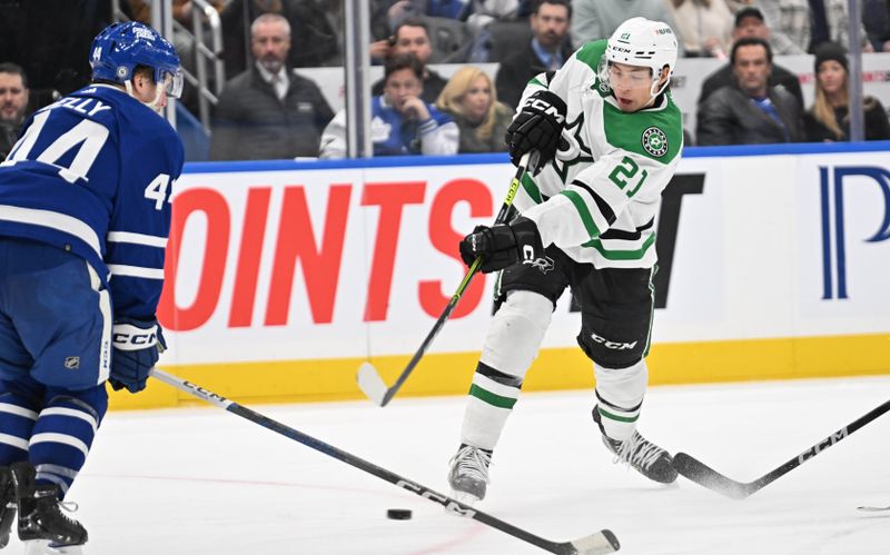 Feb 7, 2024; Toronto, Ontario, CAN; Dallas Stars forward Jason Robertson (21) shoots the puck past Toronto Maple Leafs defenseman Morgan Rielly (44) in the second period at Scotiabank Arena. Mandatory Credit: Dan Hamilton-USA TODAY Sports