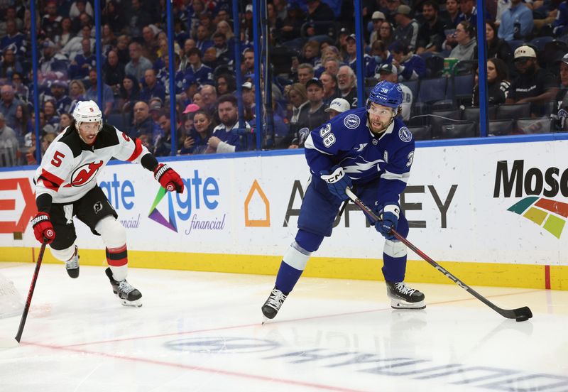 Nov 18, 2025; Tampa, Florida, USA;Tampa Bay Lightning left wing Brandon Hagel (38) skates with the puck as New Jersey Devils defenseman Brenden Dillon (5) defends  during the third period at Benchmark International Arena. Mandatory Credit: Kim Klement Neitzel-Imagn Images