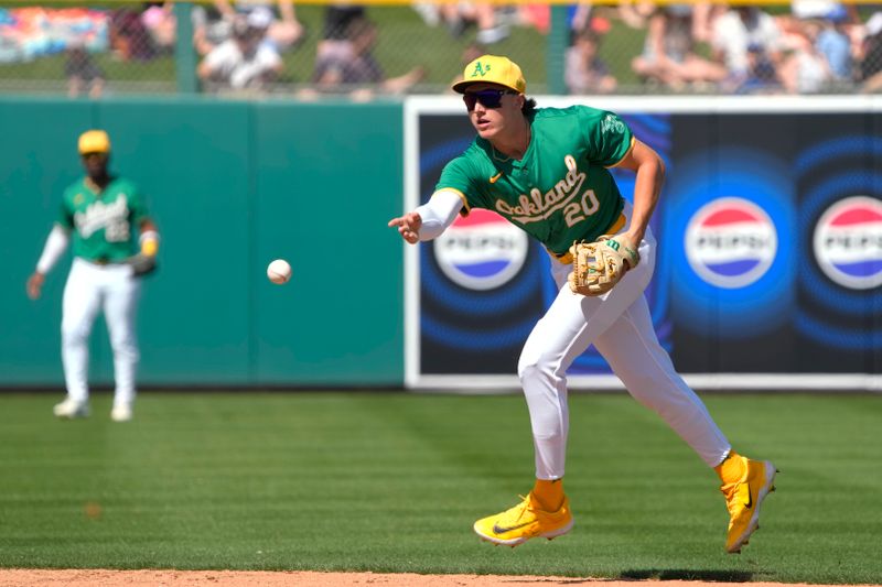 Mar 10, 2024; Mesa, Arizona, USA; Oakland Athletics second baseman Zack Gelof (20) flips the ball for an out against the Kansas City Royals in the third inning at Hohokam Stadium. Mandatory Credit: Rick Scuteri-USA TODAY Sports