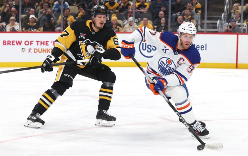 Dec 16, 2025; Pittsburgh, Pennsylvania, USA; Edmonton Oilers center Connor McDavid (97) moves the puck against Pittsburgh Penguins right wing Rickard Rakell (67) during the second period at PPG Paints Arena. Mandatory Credit: Charles LeClaire-Imagn Images