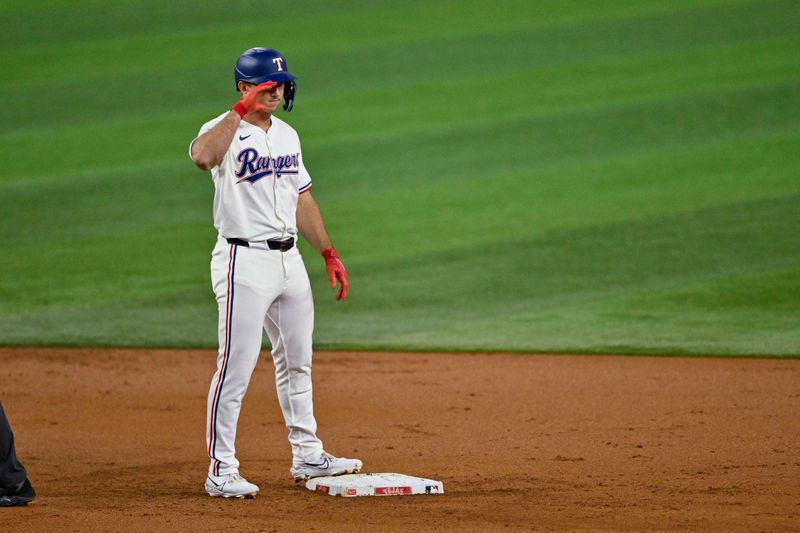 Sep 17, 2024; Arlington, Texas, USA; Texas Rangers left fielder Wyatt Langford (36) salutes his teammates after he hits a ground run double against the Toronto Blue Jays during the first inning at Globe Life Field. Mandatory Credit: Jerome Miron-Imagn Images