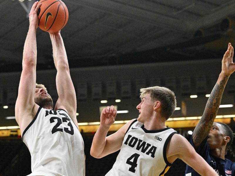 Feb 27, 2024; Iowa City, Iowa, USA; Iowa Hawkeyes forward Ben Krikke (23) and Iowa Hawkeyes guard Josh Dix (4) battle for a rebound as Penn State Nittany Lions guard Nick Kern Jr. (3) looks on during the first half at Carver-Hawkeye Arena. Mandatory Credit: Jeffrey Becker-USA TODAY Sports