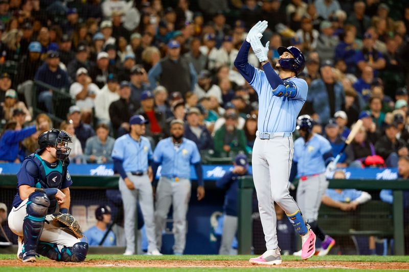 Aug 27, 2024; Seattle, Washington, USA; Tampa Bay Rays center fielder Jose Siri (22, right) celebrates while running the bases after hitting a two-run home run against the Seattle Mariners during the seventh inning at T-Mobile Park. Seattle Mariners catcher Cal Raleigh (29) waits at left. Mandatory Credit: Joe Nicholson-USA TODAY Sports