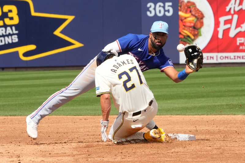 Mar 16, 2024; Phoenix, Arizona, USA;  Texas Rangers shortstop Ezequiel Duran (20) tries to get the tag on Milwaukee Brewers shortstop Willy Adames (27) in the second inning at American Family Fields of Phoenix. Mandatory Credit: Rick Scuteri-USA TODAY Sports