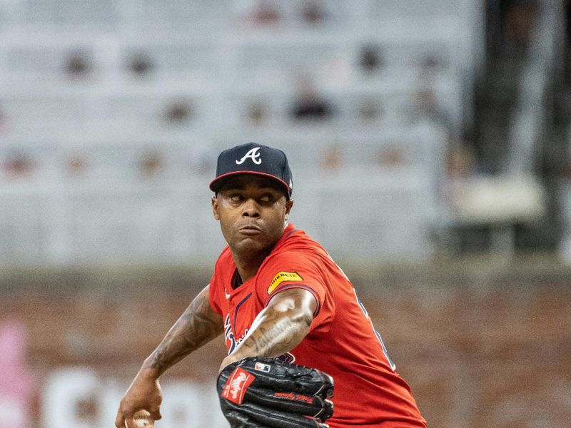 Aug 23, 2024; Cumberland, Georgia, USA; Atlanta Braves pitcher Raisel Iglesias (26) pitches the ball against Washington Nationals during the tenth inning at Truist Park. Mandatory Credit: Jordan Godfree-USA TODAY Sports
