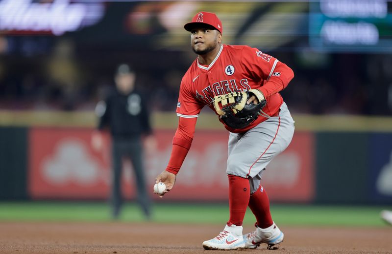 Jun 2, 2024; Seattle, Washington, USA; Los Angeles Angels first baseman Willie Calhoun (5) underhands the ball against the Seattle Mariners during the third inning at T-Mobile Park. Mandatory Credit: John Froschauer-USA TODAY Sports