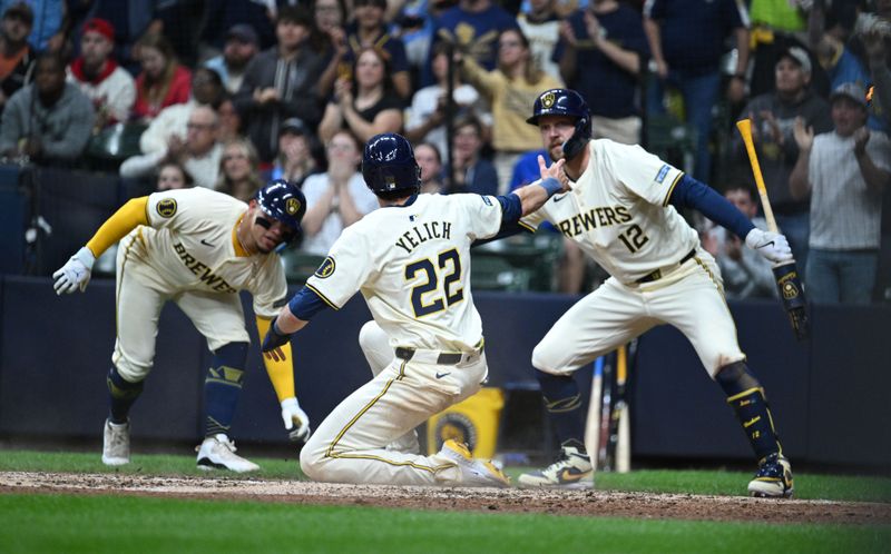 May 10, 2024; Milwaukee, Wisconsin, USA; Milwaukee Brewers outfielder Christian Yelich (22) is congratulated by Milwaukee Brewers first base Rhys Hoskins (12) after scoring a run against the St. Louis Cardinals in the fifth inning at American Family Field. Mandatory Credit: Michael McLoone-USA TODAY Sports