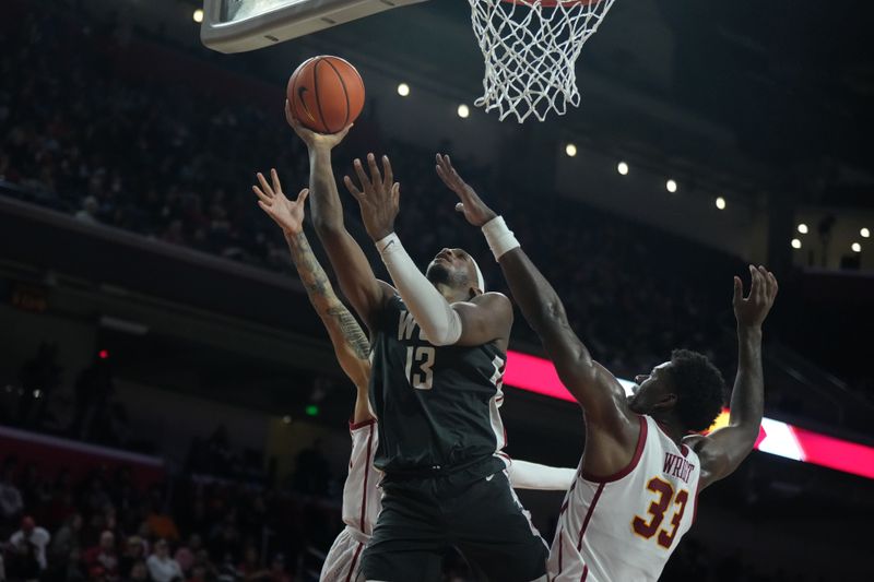 Jan 10, 2024; Los Angeles, California, USA; Washington State Cougars forward Isaac Jones (13) shoots the ball against Southern California Trojans forward Kijani Wright (33) and guard Kobe Johnson (0)  in the first half at Galen Center. Mandatory Credit: Kirby Lee-USA TODAY Sports