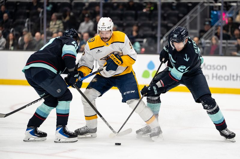 Mar 10, 2026; Seattle, Washington, USA; Nashville Predators forward Filip Forsberg (9), center, battles Seattle Kraken defenseman Ryker Evans (41), left, and defenseman Jamie Oleksiak (24) for the puck during the first period at Climate Pledge Arena. Mandatory Credit: Stephen Brashear-Imagn Images