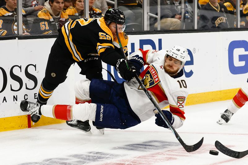 Oct 14, 2024; Boston, Massachusetts, USA; Boston Bruins defenseman Andrew Peeke (52) knocks down Florida Panthers left wing A.J. Greer (10) during the third period at TD Garden. Mandatory Credit: Winslow Townson-Imagn Images