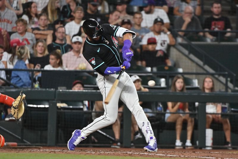 Jun 30, 2025; Phoenix, Arizona, USA;  Arizona Diamondbacks outfielder Lourdes Gurriel Jr. (12) hits a solo home run in the sixth inning against the San Francisco Giants at Chase Field. Mandatory Credit: Matt Kartozian-Imagn Images