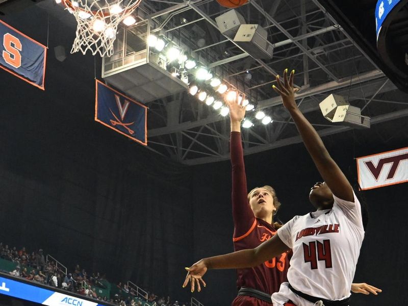 Mar 5, 2023; Greensboro, NC, USA; Louisville Cardinals forward Olivia Cochran (44) shoots past Virginia Tech Hokies center Elizabeth Kitley (33) during the first half at Greensboro Coliseum. Mandatory Credit: William Howard-USA TODAY Sports