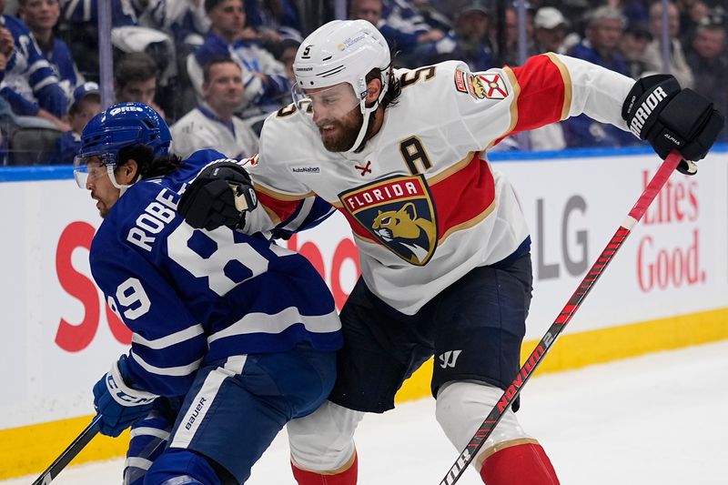May 14, 2025; Toronto, Ontario, CAN; Florida Panthers defenseman Aaron Ekblad (5) goes to check Toronto Maple Leafs forward Nicholas Robertson (89) as he goes for the puck during the third period of game five of the second round of the 2025 Stanley Cup Playoffs at Scotiabank Arena. Mandatory Credit: John E. Sokolowski-Imagn Images