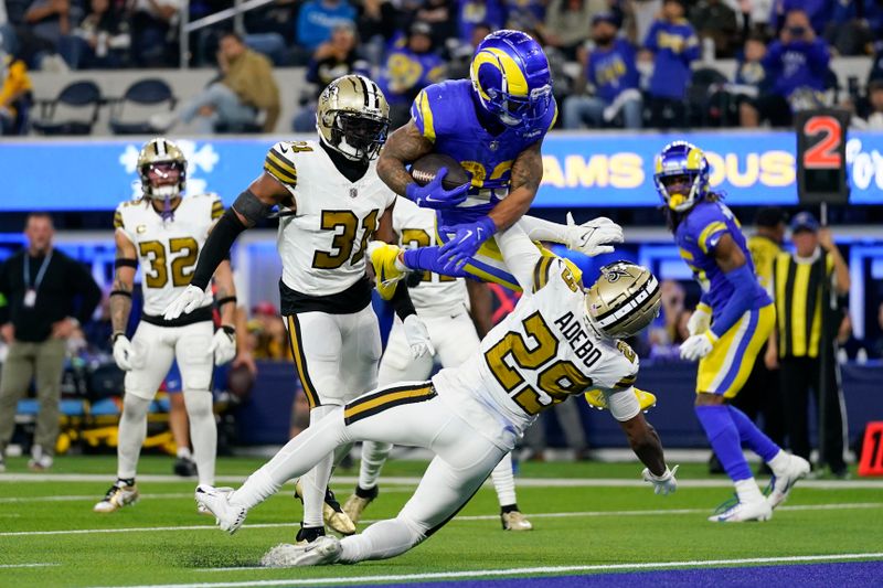 Los Angeles Rams running back Kyren Williams (23) leaps over New Orleans Saints cornerback Paulson Adebo (29) to score a rushing touchdown during the second half of an NFL football game Thursday, Dec. 21, 2023, in Inglewood, Calif. (AP Photo/Ashley Landis)