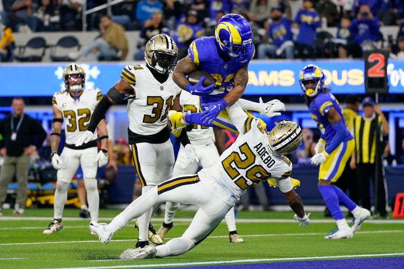 Los Angeles Rams running back Kyren Williams (23) leaps over New Orleans Saints cornerback Paulson Adebo (29) to score a rushing touchdown during the second half of an NFL football game Thursday, Dec. 21, 2023, in Inglewood, Calif. (AP Photo/Ashley Landis)