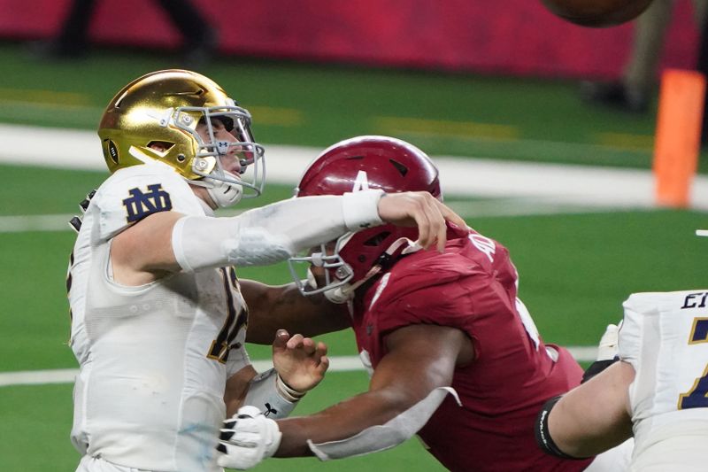 Jan 1, 2021; Arlington, TX, USA;  Notre Dame Fighting Irish quarterback Ian Book (12) passes under pressure from Alabama Crimson Tide linebacker Christopher Allen (4) in the fourth quarter during the Rose Bowl at AT&T Stadium. Mandatory Credit: Kirby Lee-USA TODAY Sports