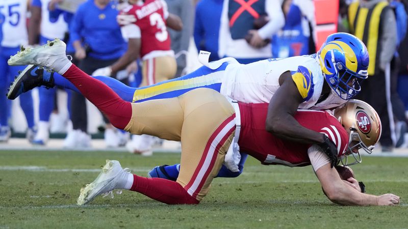 Los Angeles Rams linebacker Byron Young, top, sacks San Francisco 49ers quarterback Sam Darnold during the second half of an NFL football game in Santa Clara, Calif., Sunday, Jan. 7, 2024. (AP Photo/Loren Elliott)