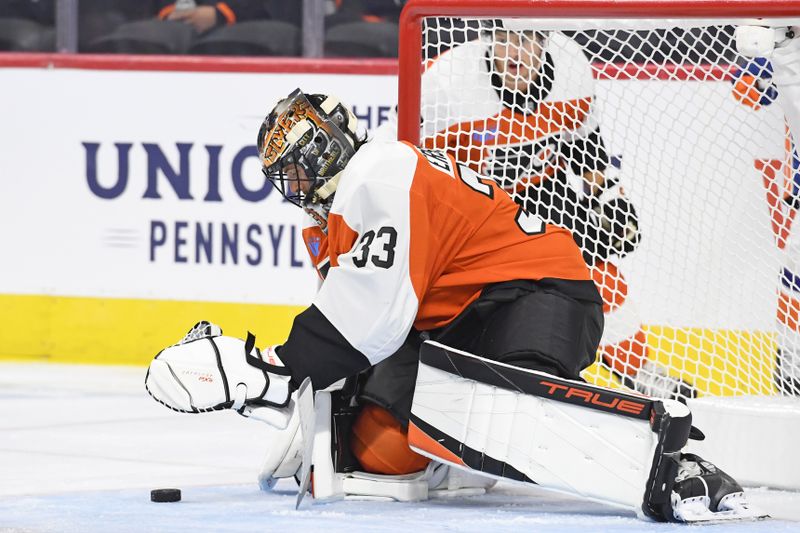 Sep 26, 2024; Philadelphia, Pennsylvania, USA; Philadelphia Flyers goaltender Samuel Ersson (33) covers the puck against the New York Islanders during the first period at Wells Fargo Center. Mandatory Credit: Eric Hartline-Imagn Images