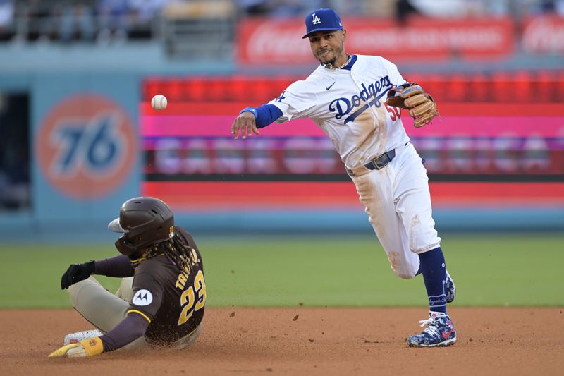 Apr 14, 2024; Los Angeles, California, USA; San Diego Padres outfielder Fernando Tatis Jr. (23) is out at second as Los Angeles Dodgers shortstop Mookie Betts (50) throws to first to complete a double play in the fifth inning at Dodger Stadium. Mandatory Credit: Jayne Kamin-Oncea-USA TODAY Sports