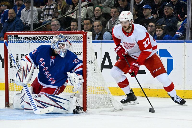 Oct 14, 2024; New York, New York, USA;  Detroit Red Wings center Michael Rasmussen (27) attempts a wrap around on New York Rangers goaltender Igor Shesterkin (31) during the second period at Madison Square Garden. Mandatory Credit: Dennis Schneidler-Imagn Images