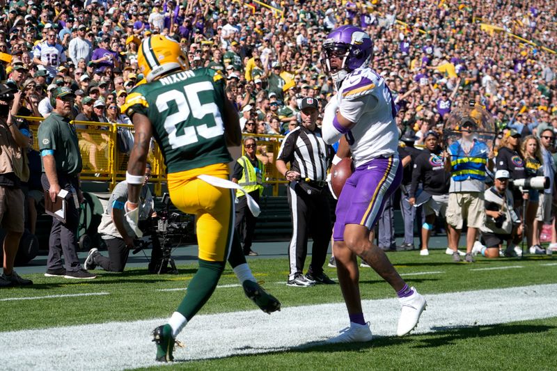 Minnesota Vikings wide receiver Justin Jefferson, right, scores a touchdown past Green Bay Packers cornerback Keisean Nixon (25) during the first half of an NFL football game Sunday, Sept. 29, 2024, in Green Bay, Wis. (AP Photo/Morry Gash)