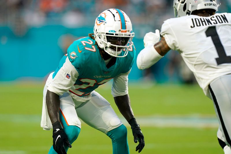 Miami Dolphins cornerback Keion Crossen (27) waits to tackle Las Vegas Raiders wide receiver Tyron Johnson (1) during the first half of a NFL preseason football game, Saturday, Aug. 20, 2022, in Miami Gardens, Fla. (AP Photo/Lynne Sladky)