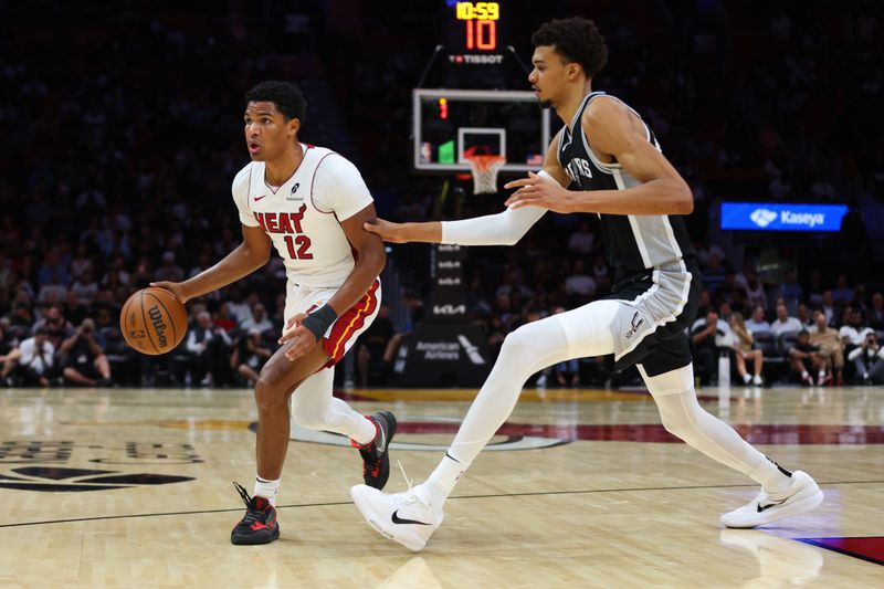 MIAMI, FLORIDA - OCTOBER 15: Dru Smith #12 of the Miami Heat drives against Victor Wembanyama #1 of the San Antonio Spurs during the second quarter of a preseason game at Kaseya Center on October 15, 2024 in Miami, Florida. NOTE TO USER: User expressly acknowledges and agrees that, by downloading and or using this photograph, User is consenting to the terms and conditions of the Getty Images License Agreement. (Photo by Megan Briggs/Getty Images)