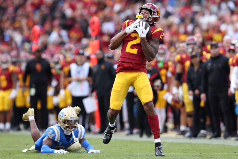 Nov 18, 2023; Los Angeles, California, USA; USC Trojans wide receiver Brenden Rice (2) catches a touchdown against UCLA Bruins defensive back Jaylin Davies (24) during the second quarter at United Airlines Field at Los Angeles Memorial Coliseum. Mandatory Credit: Jason Parkhurst-USA TODAY Sports