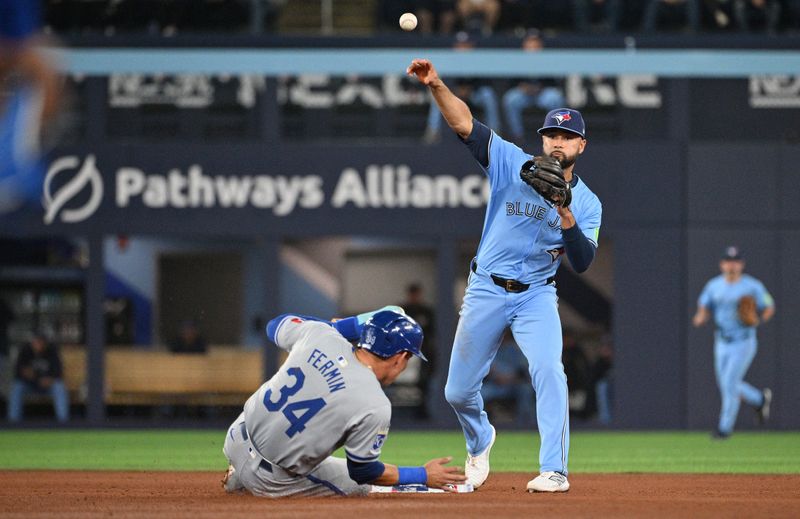 Apr 30, 2024; Toronto, Ontario, CAN;   Toronto Blue Jays second baseman Isiah Kiner-Falefa (7) throws to first base for a double play after forcing out Kansas City Royals catcher Freddy Fermin (34) in the fifth inning at Rogers Centre. Mandatory Credit: Dan Hamilton-USA TODAY Sports