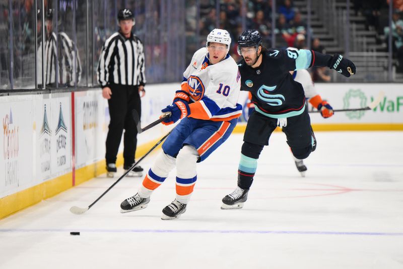 Nov 16, 2024; Seattle, Washington, USA; New York Islanders right wing Simon Holmstrom (10) passes the puck while defended by Seattle Kraken center Chandler Stephenson (9) during the second period at Climate Pledge Arena. Mandatory Credit: Steven Bisig-Imagn Images