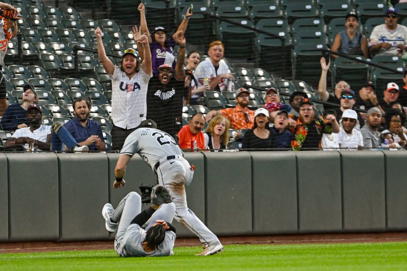 Sep 3, 2024; Baltimore, Maryland, USA;  Chicago White Sox outfielder Miguel Vargas (20) and  outfielder Andrew Benintendi (23) react after colliding on Baltimore Orioles designated hitter Eloy Jiménez (not pictured) second inning fly ball  at Oriole Park at Camden Yards. Mandatory Credit: Tommy Gilligan-Imagn Images
