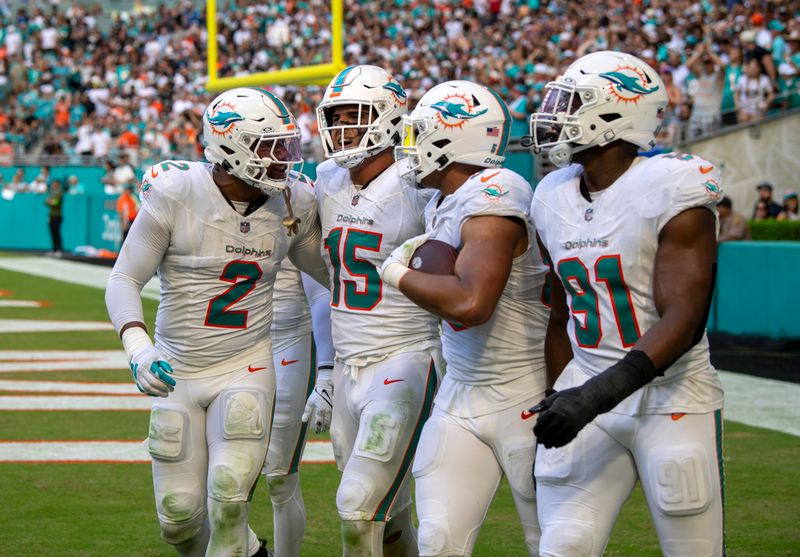Miami Dolphins defenders celebrate after a play during the second half of an NFL football game against the Las Vegas Raiders, Sunday, Nov. 19, 2023, in Miami Gardens, Fla. (AP Photo/Michael Laughlin)