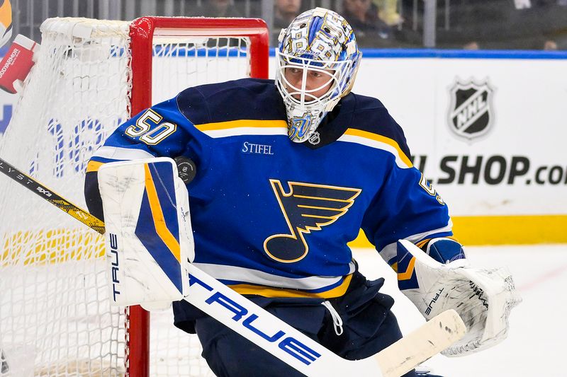 Mar 23, 2025; St. Louis, Missouri, USA;  St. Louis Blues goaltender Jordan Binnington (50) defends the net against the Nashville Predators during the first period at Enterprise Center. Mandatory Credit: Jeff Curry-Imagn Images