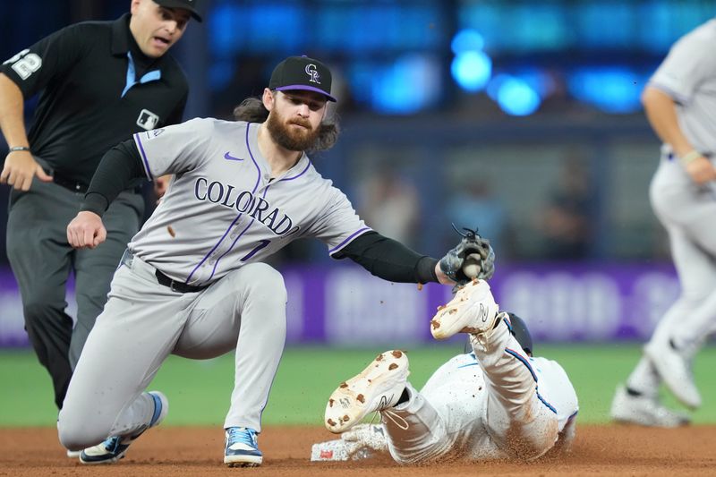 May 2, 2024; Miami, Florida, USA;  Miami Marlins right fielder Jesús Sánchez (12) steals second base under the tag of Colorado Rockies second baseman Brendan Rodgers (7) at loanDepot Park. Mandatory Credit: Jim Rassol-USA TODAY Sports