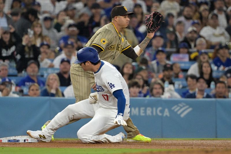 Sep 26, 2024; Los Angeles, California, USA;  Los Angeles Dodgers designated hitter Shohei Ohtani (17) beats the throw to San Diego Padres third baseman Manny Machado (13) in the seventh inning at Dodger Stadium. Mandatory Credit: Jayne Kamin-Oncea-Imagn Images