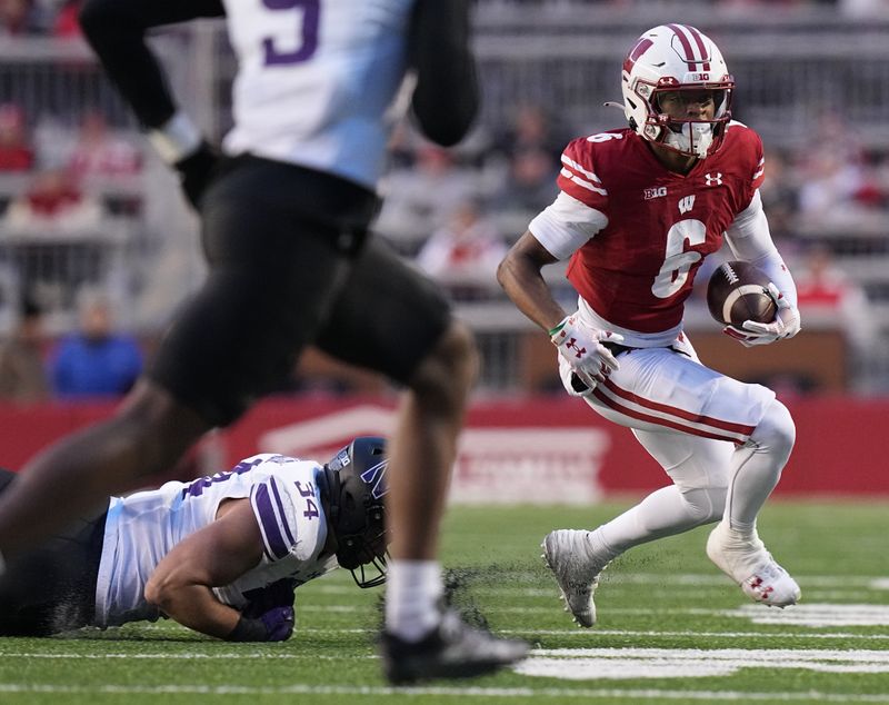 Nov 11, 2023; Madison, Wisconsin, USA; Wisconsin wide receiver Will Pauling (6) looks for running room after a reception during the third quarter against the Northwestern Wildcats at Camp Randall Stadium. Mandatory Credit: Mark Hoffman-USA TODAY Sports