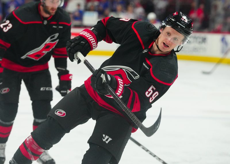 Mar 12, 2024; Raleigh, North Carolina, USA; Carolina Hurricanes left wing Jake Guentzel (59) takes a shot during the warmups before the game against the New York Rangers at PNC Arena. Mandatory Credit: James Guillory-USA TODAY Sports