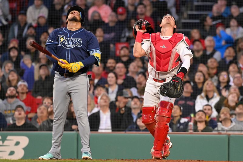 May 16, 2024; Boston, Massachusetts, USA;  Tampa Bay Rays third baseman Isaac Paredes (17) and Boston Red Sox catcher Reese McGuire (3) watch the flight of a foul ball during the third inning at Fenway Park. Mandatory Credit: Eric Canha-USA TODAY Sports