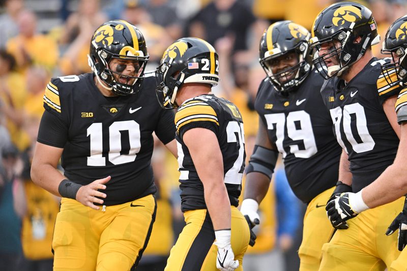 Sep 16, 2023; Iowa City, Iowa, USA; Iowa Hawkeyes quarterback Deacon Hill (10) celebrates with running back Max White (22), offensive lineman Beau Stephens (70), and offensive lineman Daijon Parker (79) after White scored a touchdown late during the fourth quarter against the Western Michigan Broncos at Kinnick Stadium. Mandatory Credit: Jeffrey Becker-USA TODAY Sports