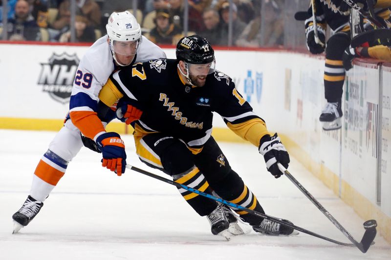 Mar 9, 2023; Pittsburgh, Pennsylvania, USA;  Pittsburgh Penguins right wing Bryan Rust (17) moves the puck up the boards against pressure from New York Islanders center Brock Nelson (29) during the first period at PPG Paints Arena. Mandatory Credit: Charles LeClaire-USA TODAY Sports