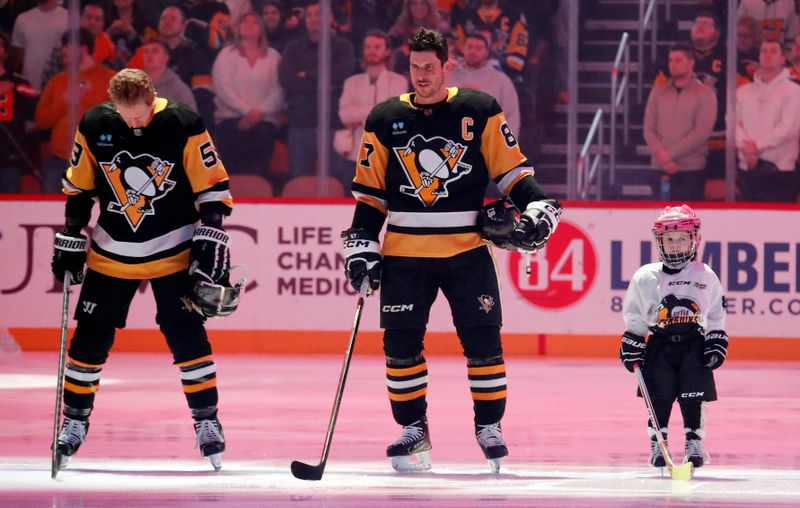 Jan 6, 2024; Pittsburgh, Pennsylvania, USA;  Little Penguins youth hockey participant Samantha Britt (right) stands for the national anthem alongside Pittsburgh Penguins center Sidney Crosby (87) and left wing Jake Guentzel (59) before a game against the Buffalo Sabres at PPG Paints Arena. Mandatory Credit: Charles LeClaire-USA TODAY Sports