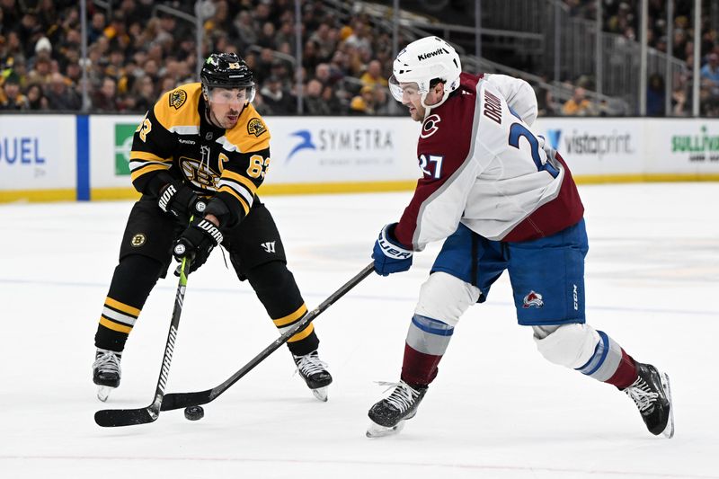 Jan 25, 2025; Boston, Massachusetts, USA; Colorado Avalanche left wing Jonathan Drouin (27) passes the puck against Boston Bruins left wing Brad Marchand (63) during the second period at the TD Garden. Mandatory Credit: Brian Fluharty-Imagn Images