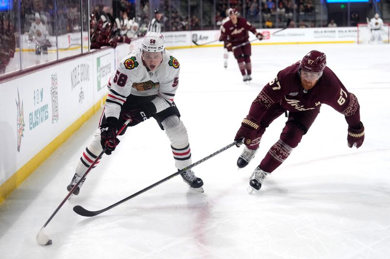 Mar 18, 2023; Tempe, Arizona, USA; Chicago Blackhawks right wing MacKenzie Entwistle (58) skates against Arizona Coyotes left wing Lawson Crouse (67) during the first period at Mullett Arena. Mandatory Credit: Joe Camporeale-USA TODAY Sports