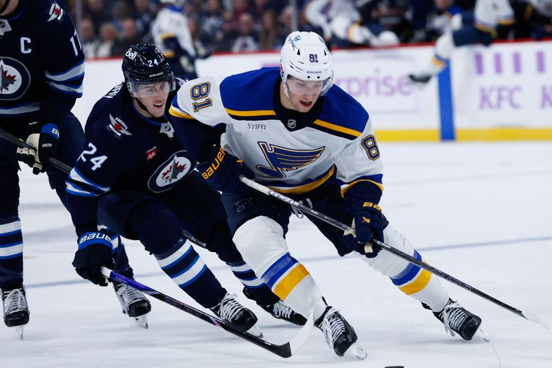 Dec 3, 2024; Winnipeg, Manitoba, CAN;  St. Louis Blues forward Dylan Holloway (71) shields the puck from Winnipeg Jets defenseman Hayden Fleury (24) during the first period at Canada Life Centre. Mandatory Credit: Terrence Lee-Imagn Images