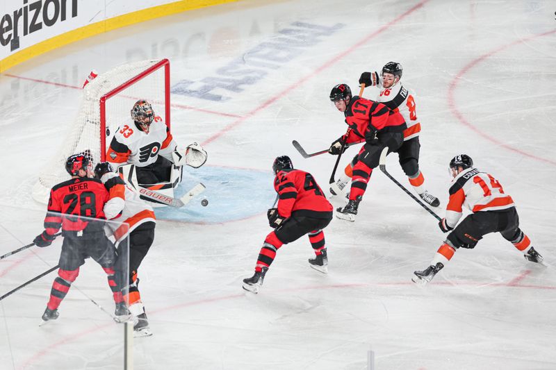 Feb 17, 2024; East Rutherford, New Jersey, USA; Philadelphia Flyers goaltender Samuel Ersson (33) makes a save on New Jersey Devils center Curtis Lazar (42) during the second period in a Stadium Series ice hockey game at MetLife Stadium. Mandatory Credit: Vincent Carchietta-USA TODAY Sports