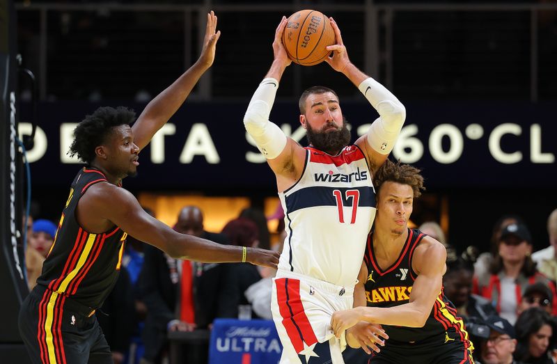 ATLANTA, GEORGIA - NOVEMBER 15:  Jonas Valanciunas #17 of the Washington Wizards grabs a rebound against Clint Capela #15 and Dyson Daniels #5 of the Atlanta Hawks during the fourth quarter of the Emirates NBA Cup game at State Farm Arena on November 15, 2024 in Atlanta, Georgia.  NOTE TO USER: User expressly acknowledges and agrees that, by downloading and/or using this photograph, user is consenting to the terms and conditions of the Getty Images License Agreement.  (Photo by Kevin C. Cox/Getty Images)