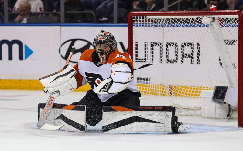 Apr 11, 2024; New York, New York, USA; Philadelphia Flyers goalie Samuel Ersson (33) makes a glove save against the New York Rangers during the first period at Madison Square Garden. Mandatory Credit: Danny Wild-USA TODAY Sports